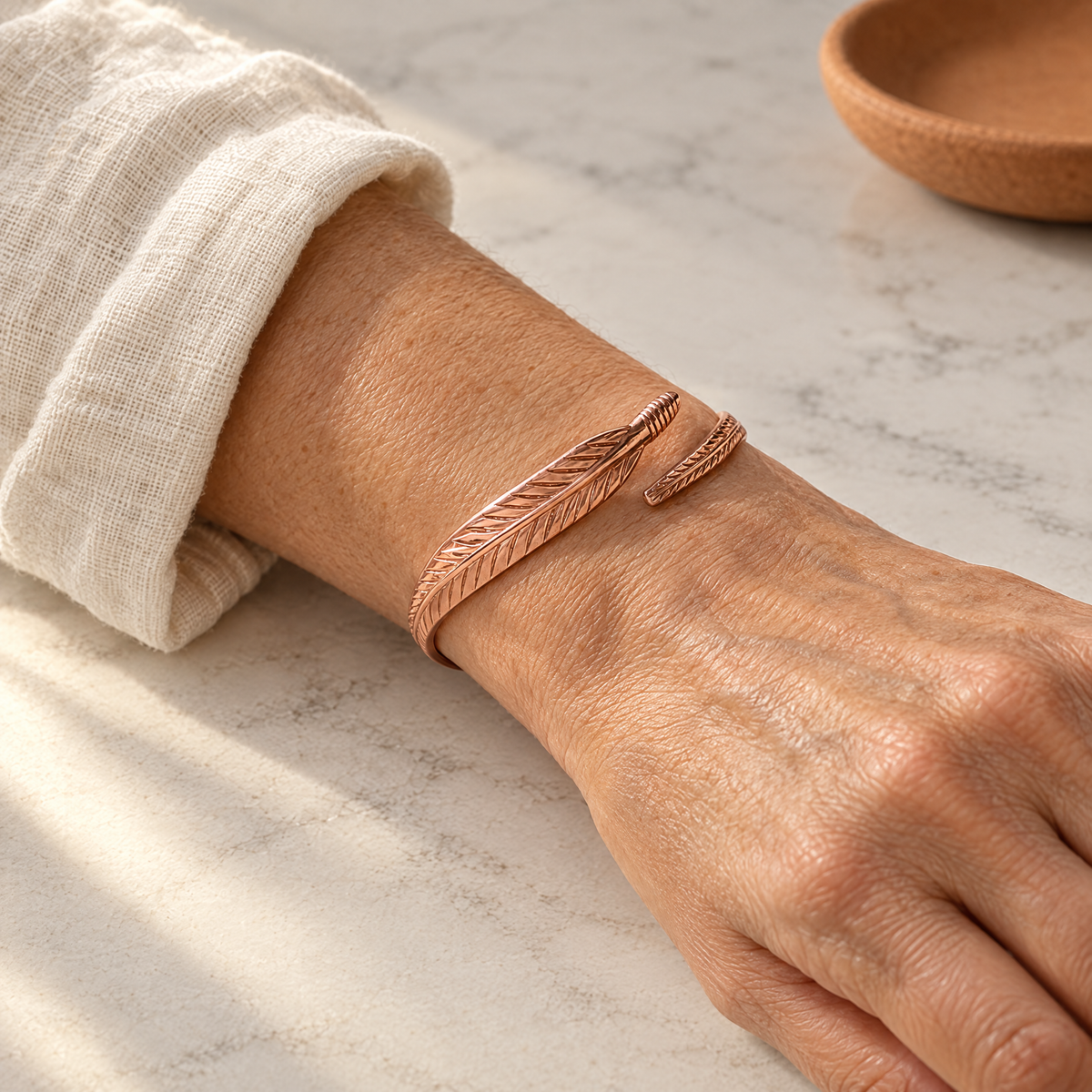 June's Feather Copper Bracelet – pure copper bracelet on a warm neutral background - photo 2